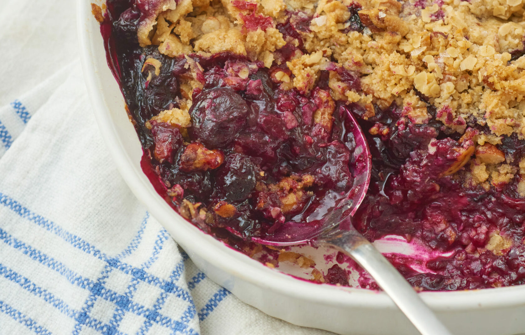 A blueberry cobbler with a spoon in it