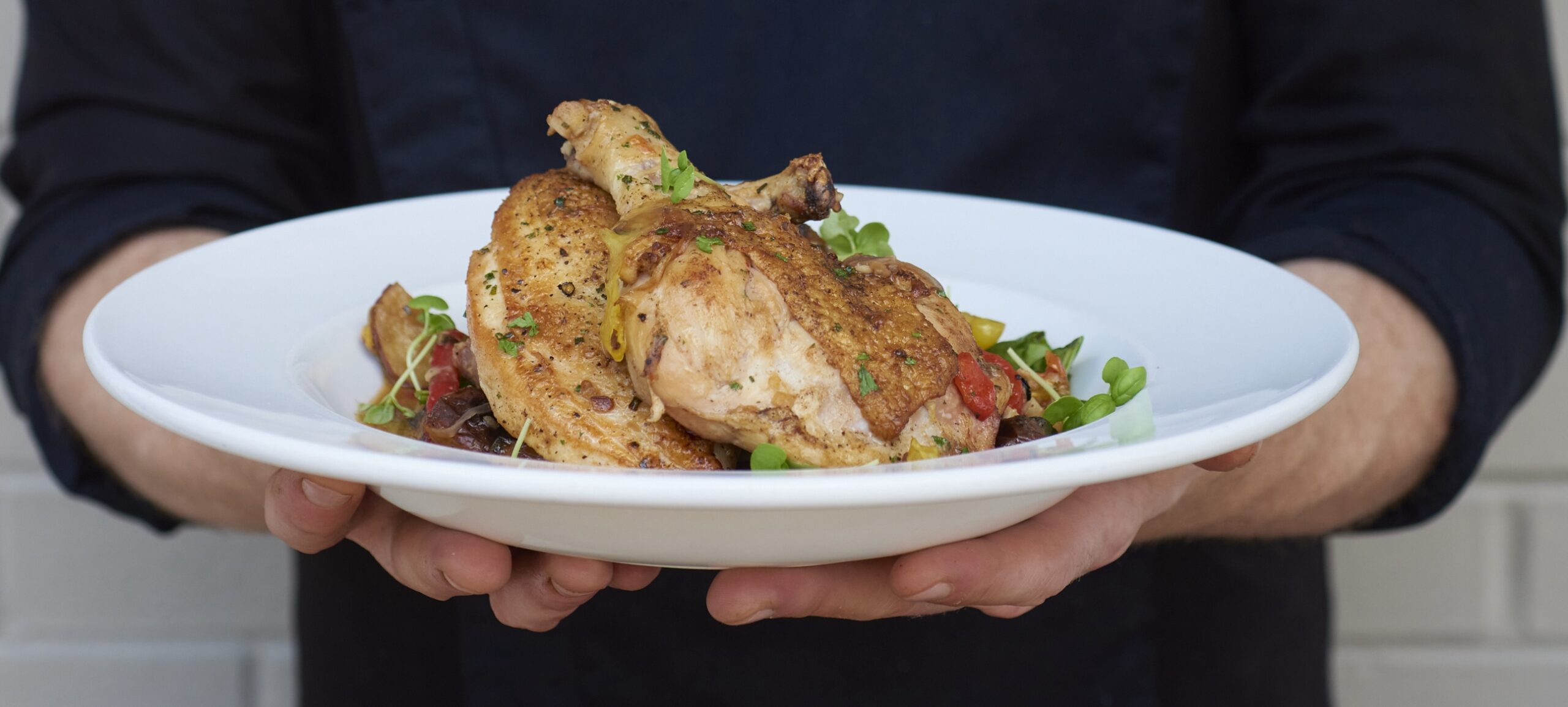 A man holding a ball with a chicken dish in it food porn