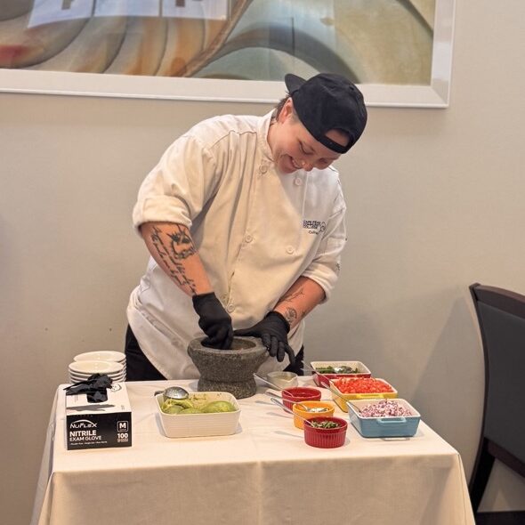 woman in chef's white making guacamole