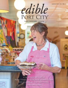 cover of edible port city magazine smiling lady in pink apron