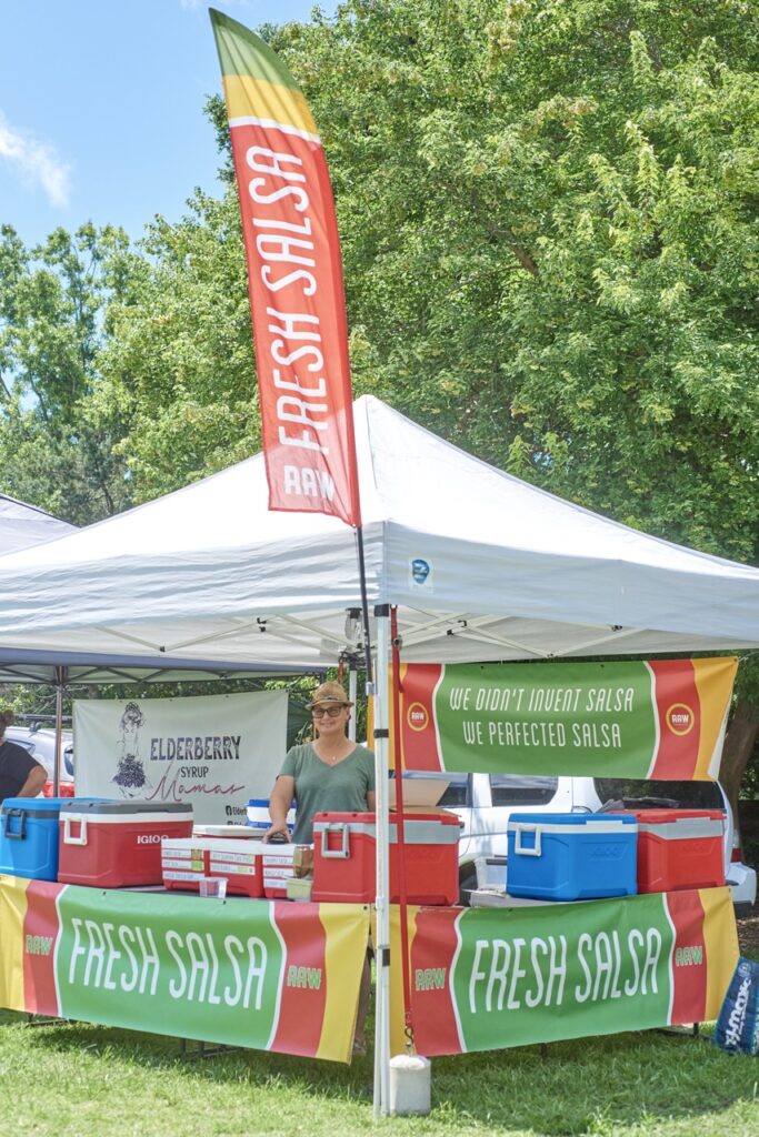 tent at farmer market with flags say selling salsa
