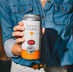 person in blue shirt holds a can of Wilmington Brewing Co pretty pumpkin ale